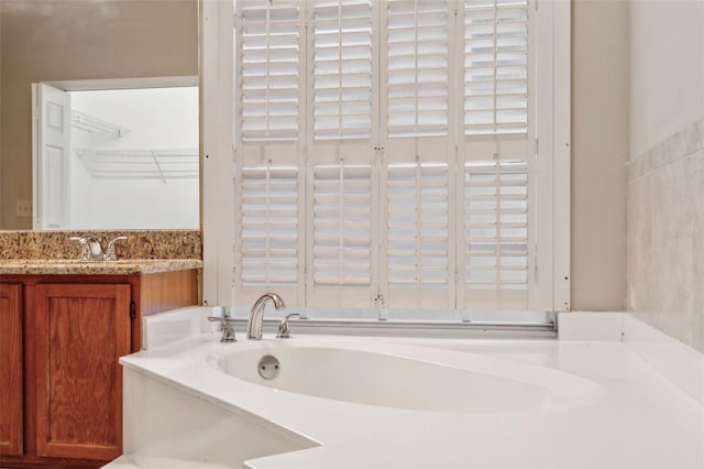 bathroom with vanity and a washtub