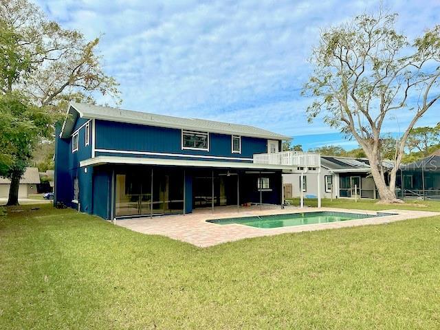 back of property with a lawn and a patio area