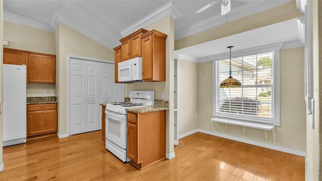 kitchen with light stone counters, pendant lighting, light hardwood / wood-style floors, white appliances, and ornamental molding