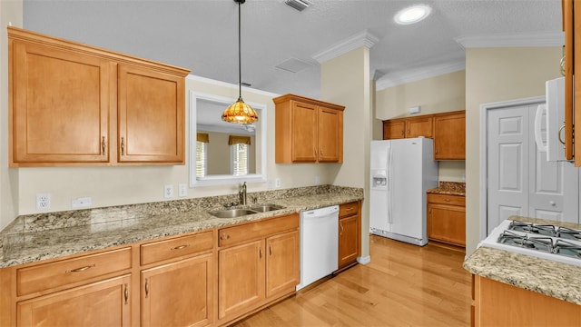 kitchen with pendant lighting, crown molding, white appliances, and sink