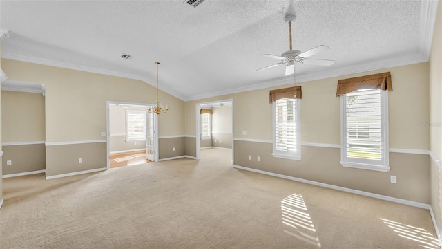 carpeted spare room with a textured ceiling, ceiling fan with notable chandelier, vaulted ceiling, and ornamental molding