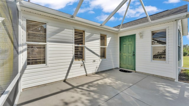 view of exterior entry with a patio area