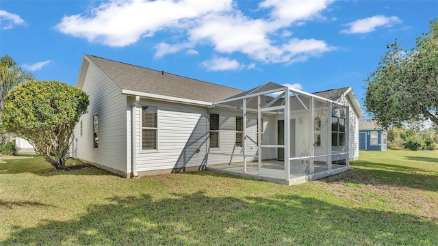 view of front of property featuring a front yard, a patio, and glass enclosure