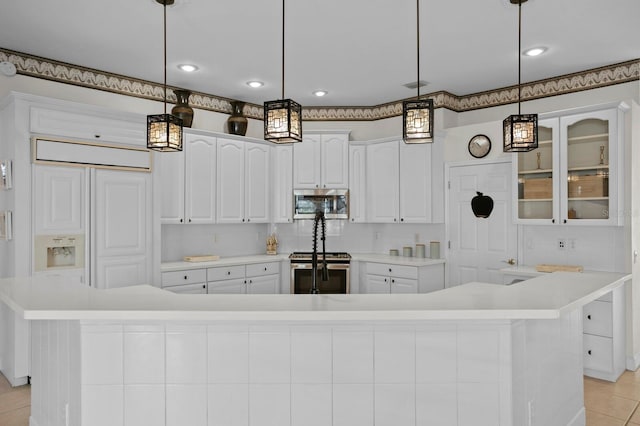 kitchen featuring appliances with stainless steel finishes, decorative light fixtures, white cabinetry, light tile patterned floors, and a spacious island