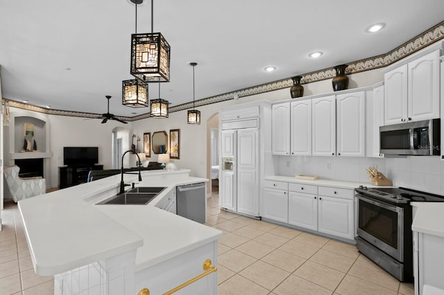 kitchen featuring stainless steel appliances, white cabinetry, hanging light fixtures, and sink