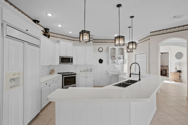 kitchen with white cabinetry, sink, a large island, light tile patterned floors, and stainless steel appliances