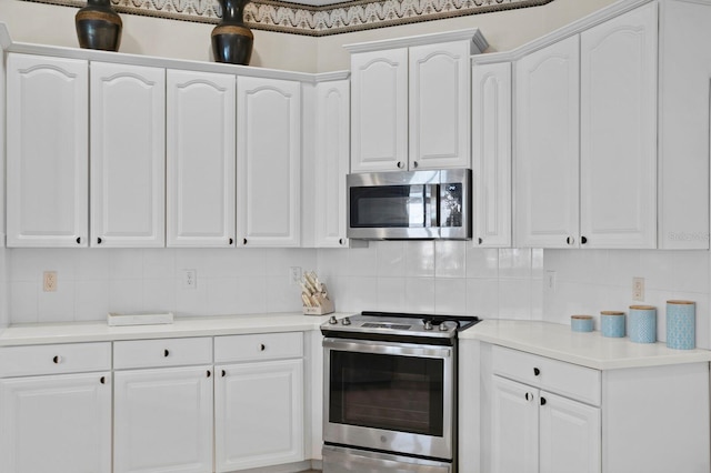 kitchen featuring stainless steel appliances, white cabinets, and decorative backsplash