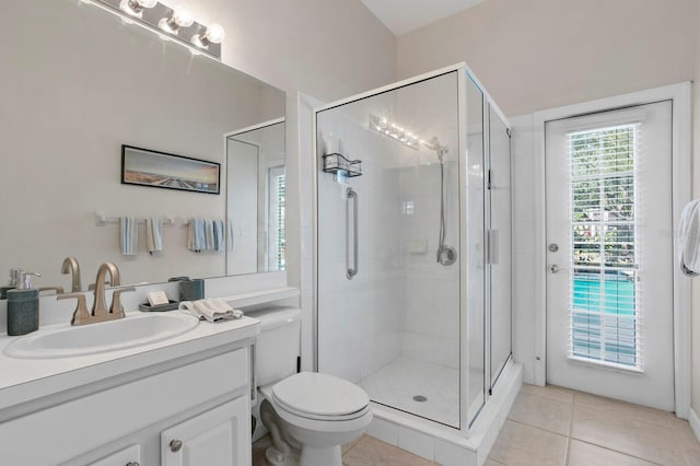 bathroom featuring vanity, toilet, a shower with shower door, and tile patterned flooring