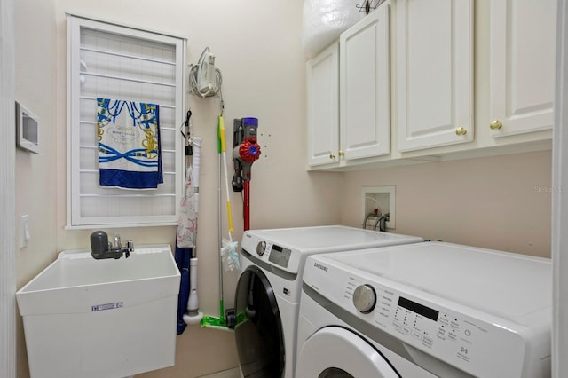 clothes washing area featuring sink, cabinets, and washing machine and clothes dryer