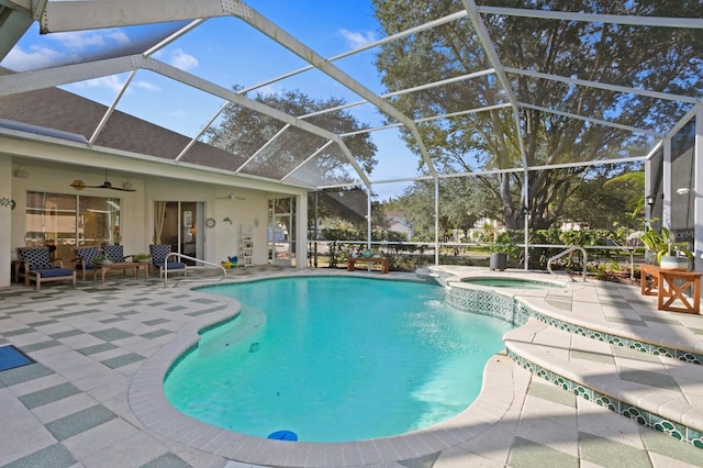 view of pool with an in ground hot tub, a patio, ceiling fan, and glass enclosure