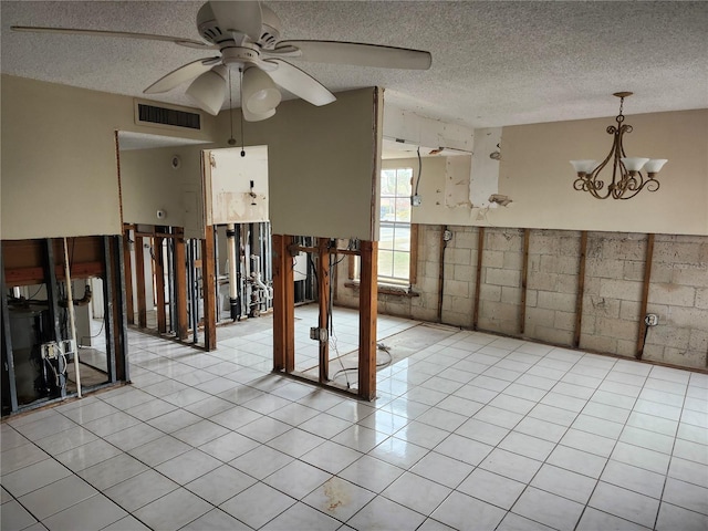 interior space with a textured ceiling and ceiling fan with notable chandelier