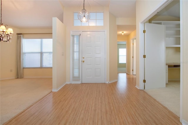 foyer entrance featuring a notable chandelier and light wood-type flooring