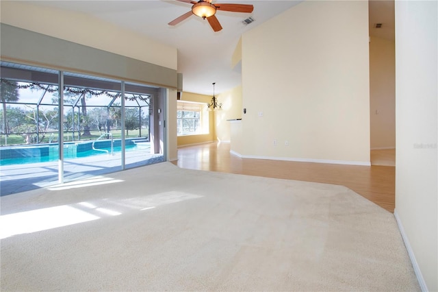 empty room featuring hardwood / wood-style floors, high vaulted ceiling, and ceiling fan