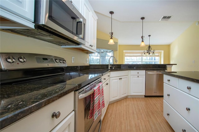 kitchen with sink, light hardwood / wood-style flooring, stainless steel appliances, white cabinets, and decorative light fixtures