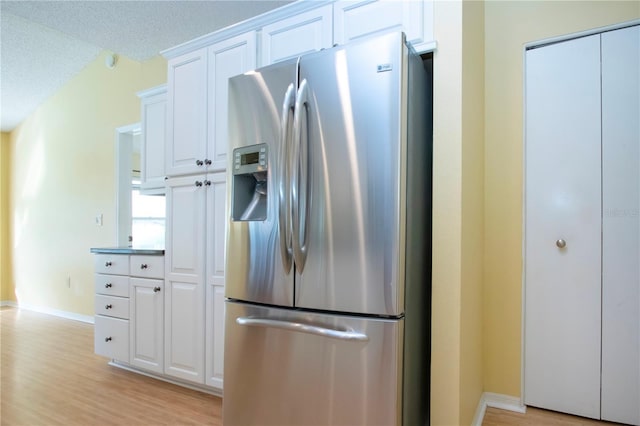 kitchen featuring white cabinetry, light hardwood / wood-style flooring, a textured ceiling, and stainless steel fridge with ice dispenser