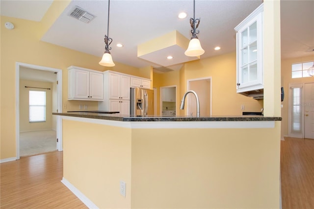 kitchen with pendant lighting, white cabinetry, sink, stainless steel refrigerator with ice dispenser, and light hardwood / wood-style flooring