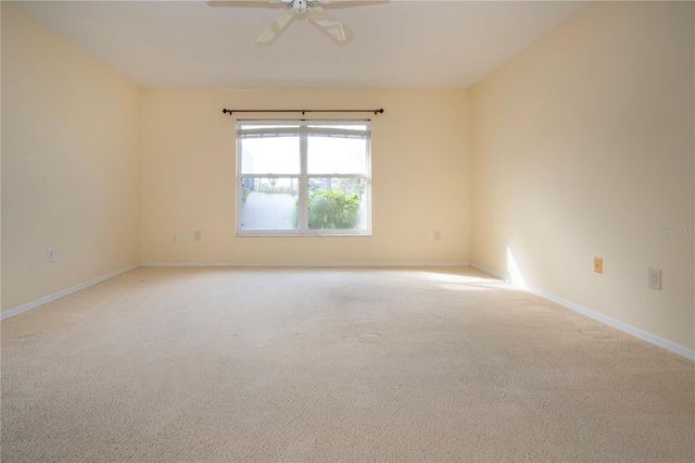 spare room featuring light colored carpet and ceiling fan