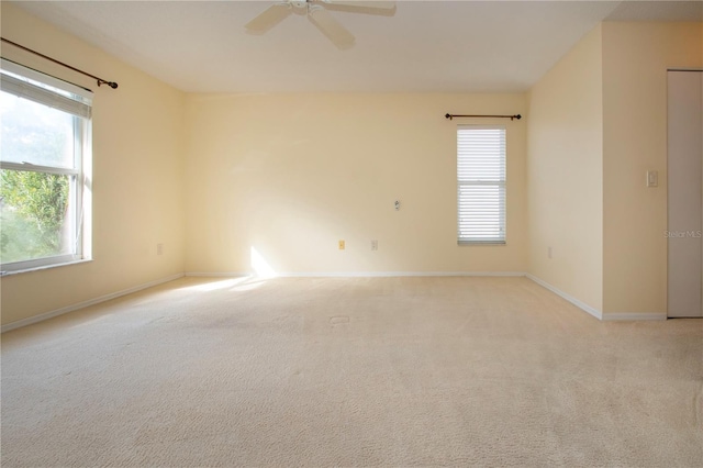 carpeted spare room with ceiling fan