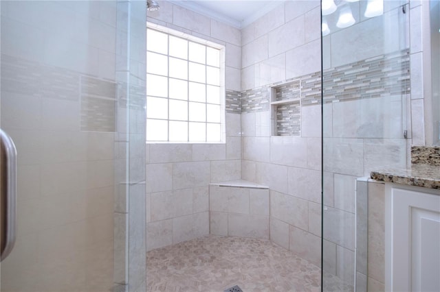 bathroom with vanity, a shower with shower door, and ornamental molding