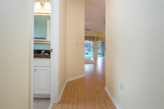 hall featuring a notable chandelier and light hardwood / wood-style floors