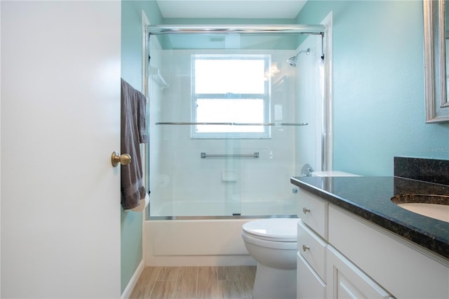 full bathroom with toilet, vanity, and bath / shower combo with glass door