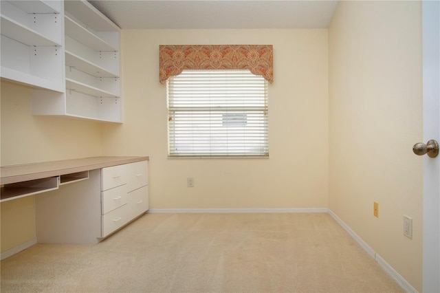 unfurnished office with light carpet and built in desk