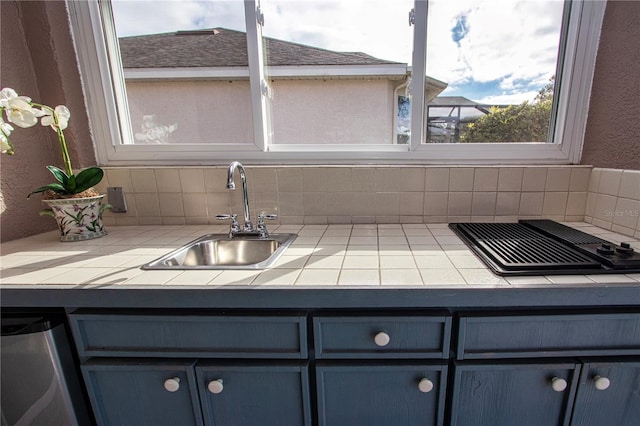 kitchen featuring blue cabinets, sink, tile counters, dishwasher, and backsplash