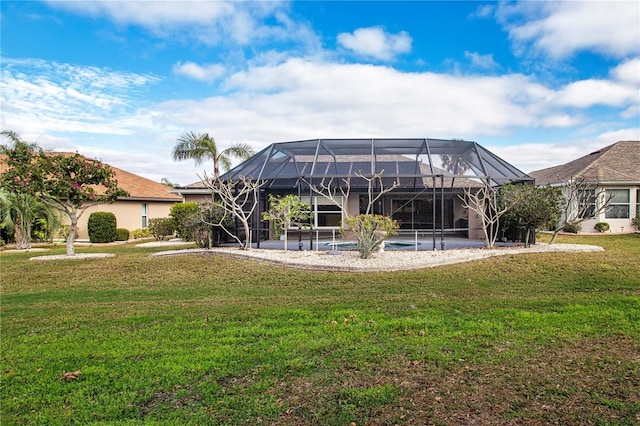 rear view of house with glass enclosure and a lawn