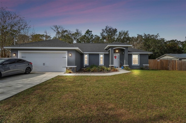 ranch-style home featuring a yard and a garage