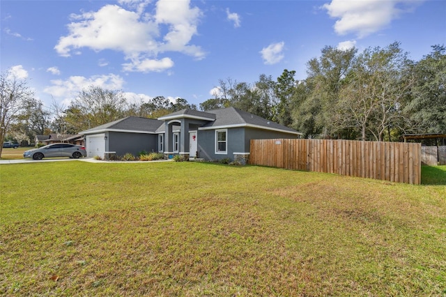 ranch-style house featuring a garage and a front lawn