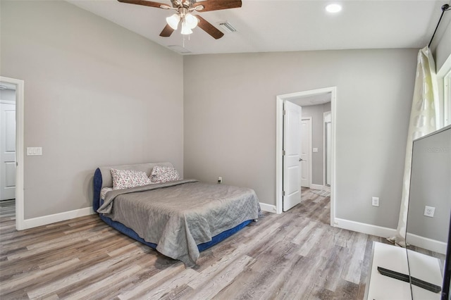 bedroom with ceiling fan, light hardwood / wood-style floors, and lofted ceiling