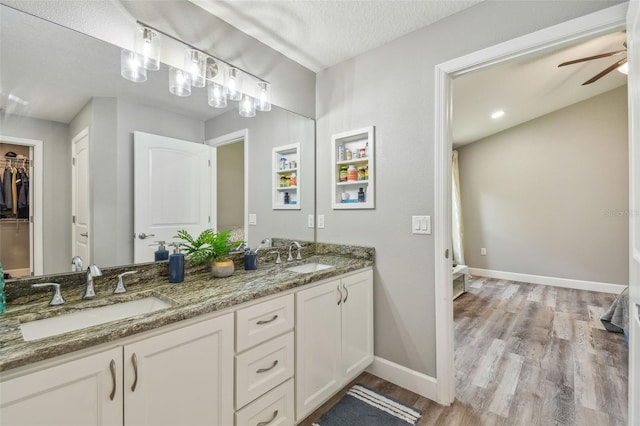 bathroom with vanity, hardwood / wood-style floors, a textured ceiling, and ceiling fan