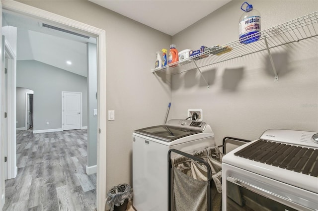 laundry room featuring washer and dryer and light hardwood / wood-style flooring