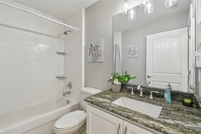 full bathroom with toilet, vanity, and tiled shower / bath