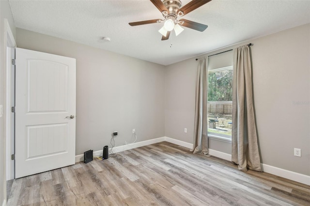 empty room with ceiling fan, light hardwood / wood-style floors, and a textured ceiling