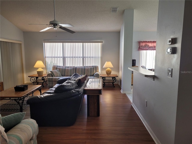 living room featuring a textured ceiling, dark hardwood / wood-style floors, and ceiling fan