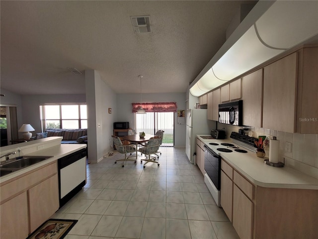 kitchen with light brown cabinetry, white appliances, and pendant lighting