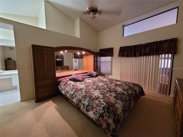 bedroom with ceiling fan, high vaulted ceiling, and light carpet