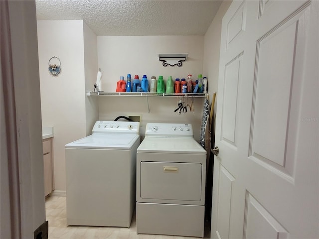 laundry area featuring washer and dryer and a textured ceiling