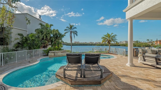 view of pool with a water view and a patio area