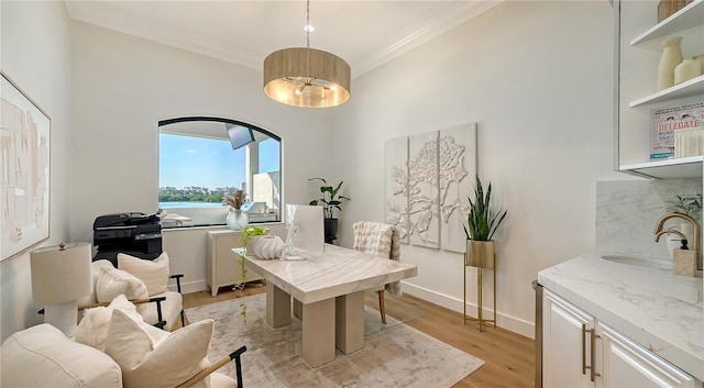 office featuring sink, light hardwood / wood-style floors, and ornamental molding