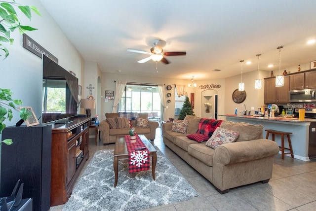 living room with ceiling fan, light tile patterned floors, and sink