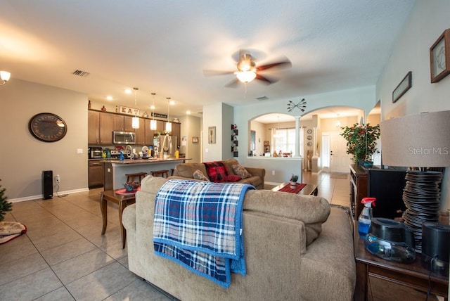 living room featuring ceiling fan and light tile patterned floors