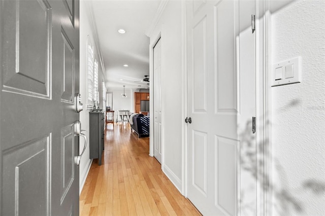 corridor featuring light hardwood / wood-style floors and crown molding