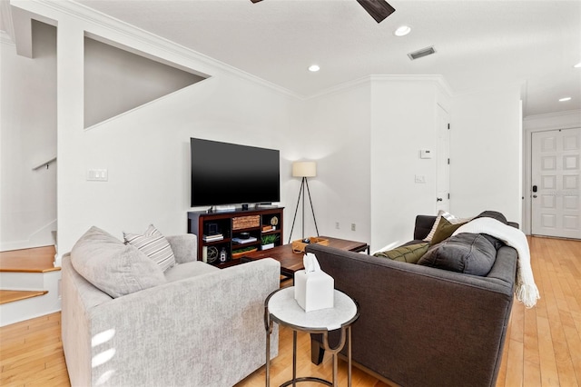 living room featuring light wood-type flooring and crown molding