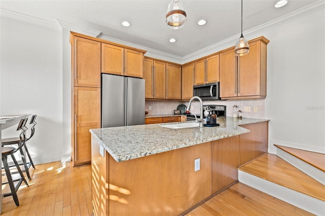 kitchen featuring kitchen peninsula, hanging light fixtures, ornamental molding, and appliances with stainless steel finishes