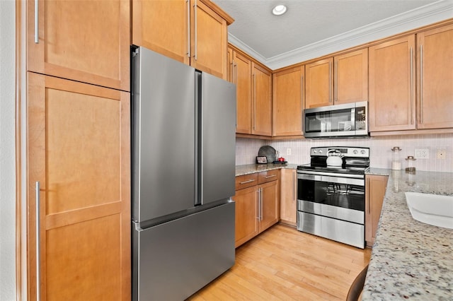 kitchen with decorative backsplash, light stone counters, stainless steel appliances, crown molding, and light hardwood / wood-style floors