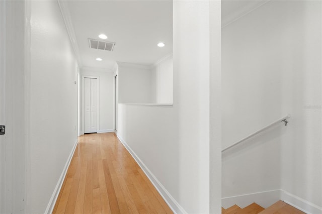 hallway with hardwood / wood-style flooring and ornamental molding