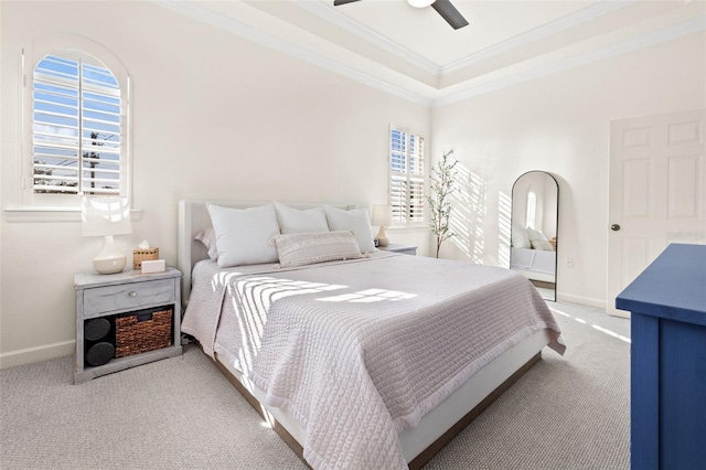 carpeted bedroom featuring ceiling fan, a raised ceiling, and ornamental molding