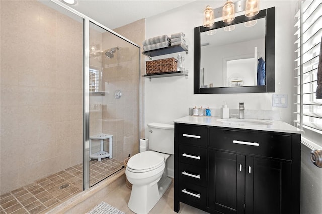 bathroom with tile patterned flooring, vanity, toilet, and a shower with shower door